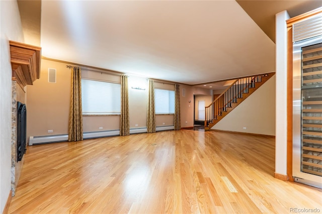 unfurnished living room with light hardwood / wood-style floors, a baseboard radiator, beverage cooler, and ornamental molding