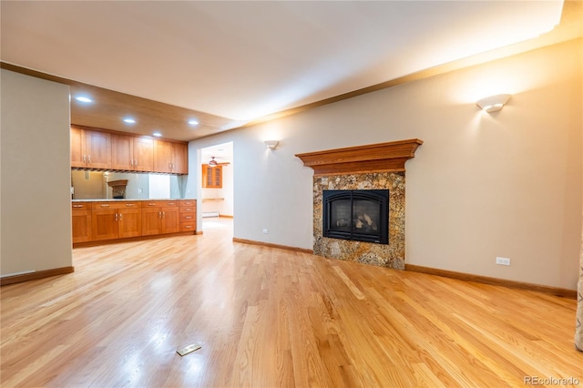 unfurnished living room featuring a high end fireplace and light hardwood / wood-style flooring