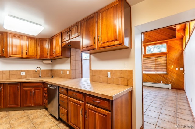 kitchen with a baseboard heating unit, light tile patterned flooring, sink, and tile countertops