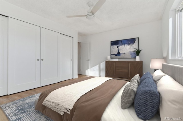 bedroom with ceiling fan, a closet, and hardwood / wood-style floors