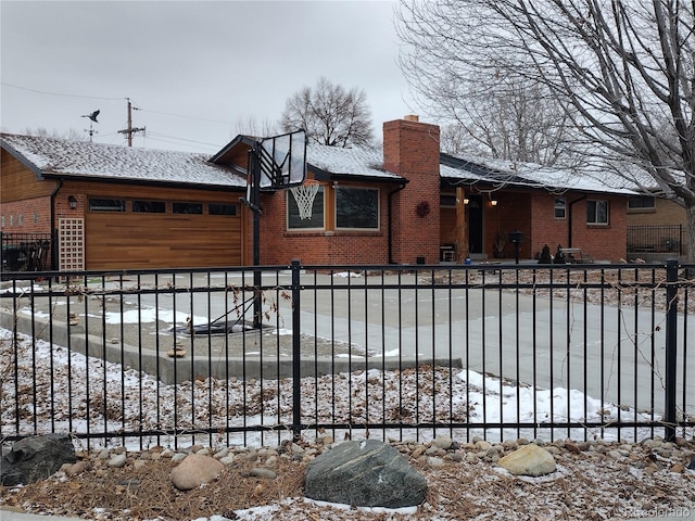 snow covered gate featuring a garage