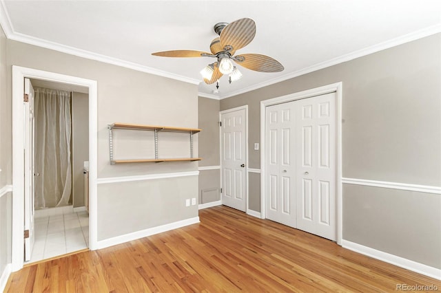 unfurnished bedroom featuring ensuite bathroom, light wood-type flooring, a closet, and crown molding