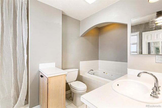 bathroom featuring toilet, vanity, tile patterned flooring, and tiled bath