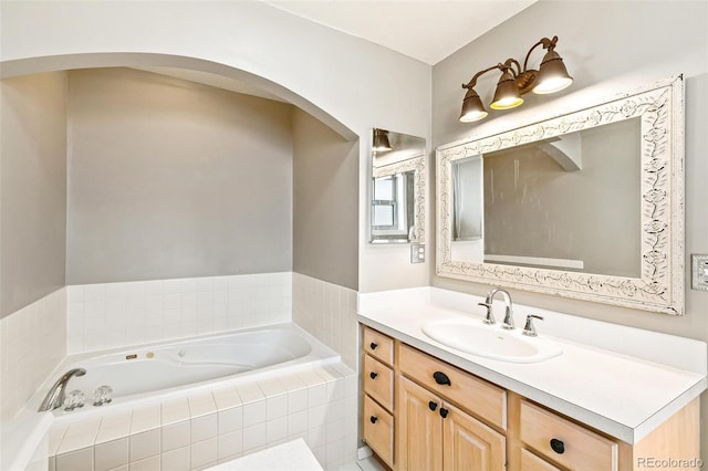 bathroom with vanity and tiled tub