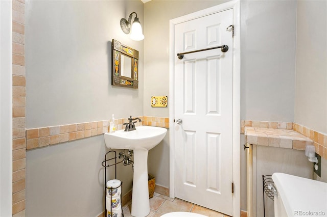 bathroom with tile patterned floors and tile walls