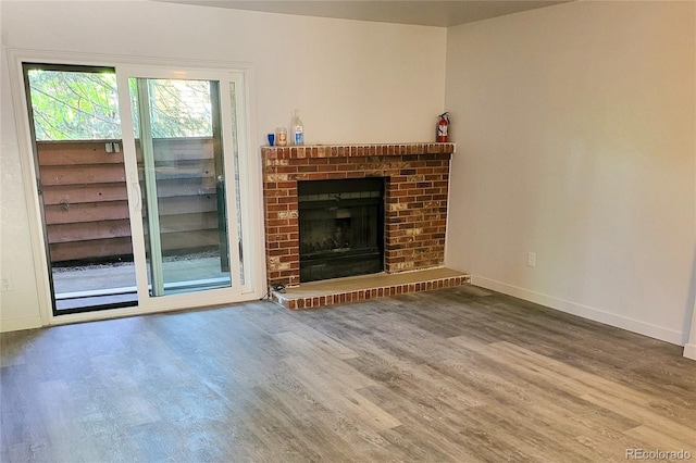 2261 S Buckley Rd Unit 102, Aurora, CO 80013 - unfurnished living room featuring wood finished floors, baseboards, and a fireplace