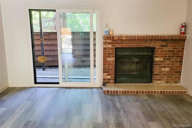 2261 S Buckley Rd Unit 102, Aurora, CO 80013 - unfurnished living room with wood finished floors, a brick fireplace, and baseboards