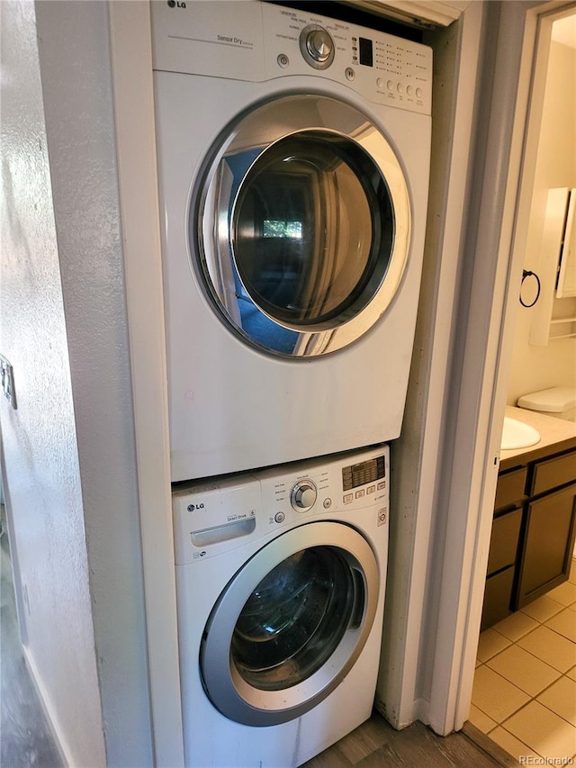 2261 S Buckley Rd Unit 102, Aurora, CO 80013 - washroom featuring stacked washer / dryer and tile patterned flooring