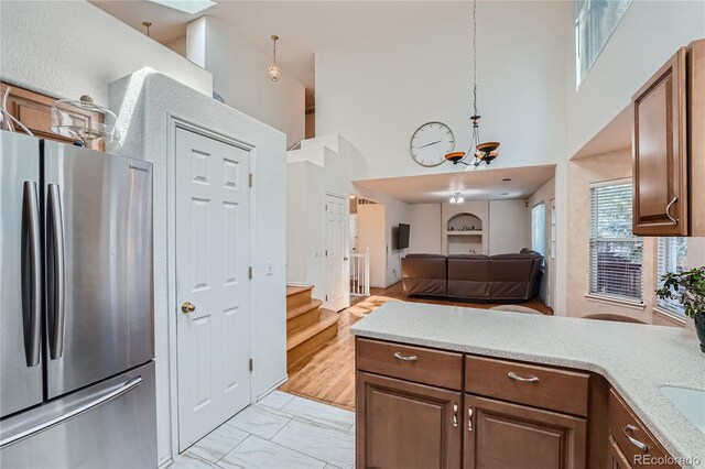 18872 E Prentice Pl, Centennial, CO 80015 - kitchen featuring freestanding refrigerator, a high ceiling, a chandelier, light countertops, and open floor plan