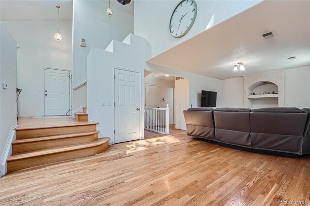18872 E Prentice Pl, Centennial, CO 80015 - living area featuring built in shelves, wood finished floors, a towering ceiling, and stairs