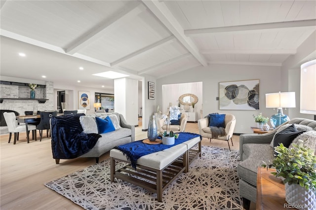 living room featuring vaulted ceiling with beams and light hardwood / wood-style floors