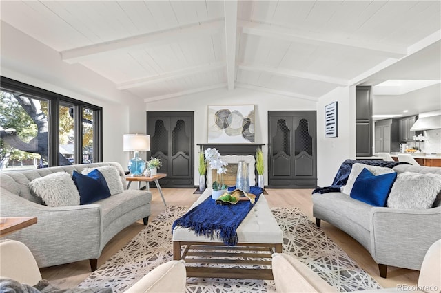 living room featuring light hardwood / wood-style floors and vaulted ceiling with beams