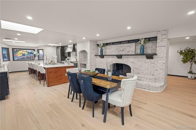 dining area featuring light hardwood / wood-style flooring and a fireplace