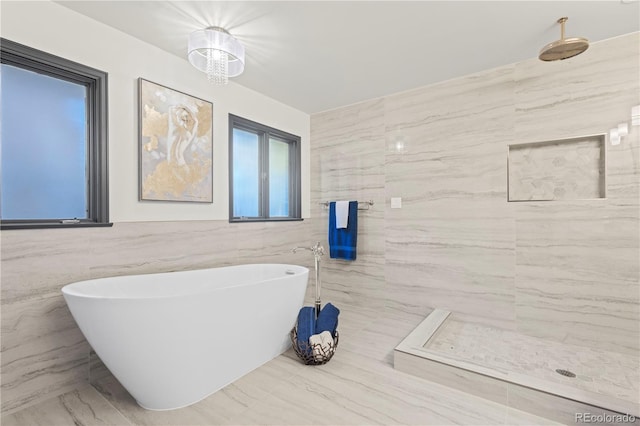 bathroom with tile walls and separate shower and tub