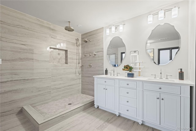 bathroom with vanity and tiled shower