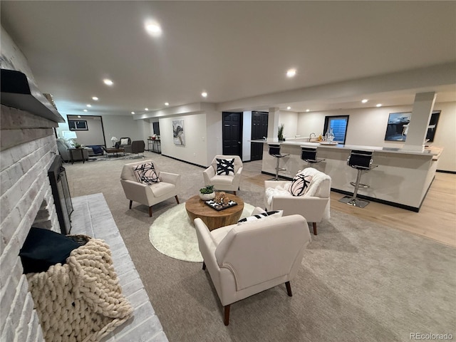 carpeted living room featuring a brick fireplace