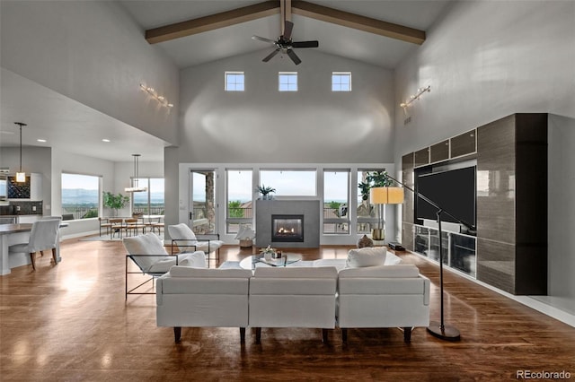 living room featuring a glass covered fireplace, beam ceiling, ceiling fan, and wood finished floors