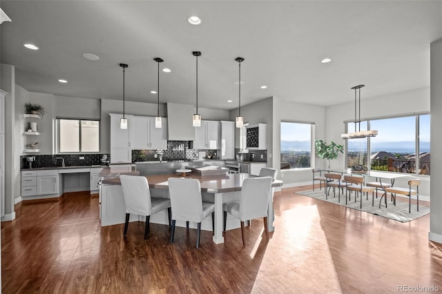 kitchen featuring tasteful backsplash, a center island, dark wood-style flooring, and white cabinetry