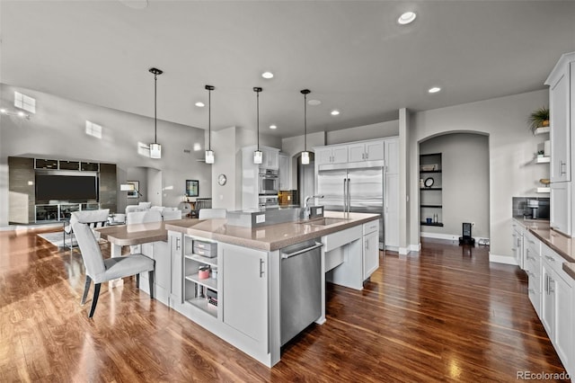 kitchen with arched walkways, open shelves, a sink, and stainless steel appliances