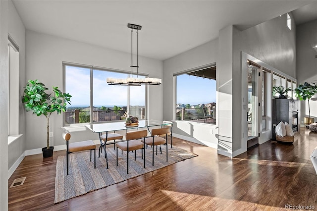 dining room with a chandelier, visible vents, baseboards, and wood finished floors