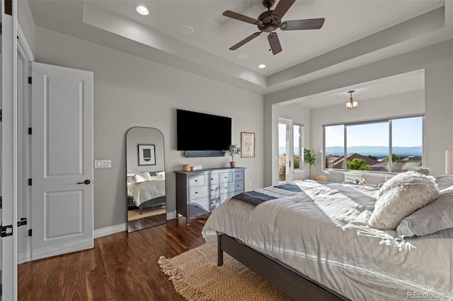 bedroom featuring recessed lighting, a raised ceiling, ceiling fan, wood finished floors, and baseboards