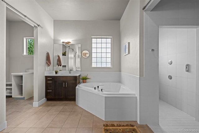 bathroom with a walk in shower, a garden tub, vanity, and tile patterned floors