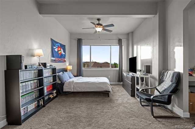 carpeted bedroom featuring ceiling fan, baseboards, and beamed ceiling