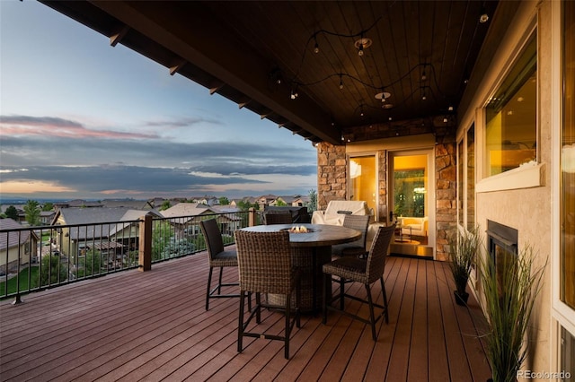 deck at dusk featuring a residential view and outdoor dining space