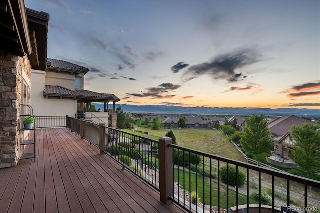 deck at dusk with a mountain view and a residential view