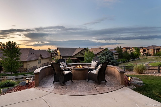 view of patio featuring a fire pit, fence, and a residential view