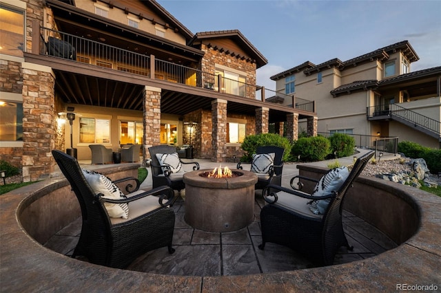 view of patio with a balcony and a fire pit