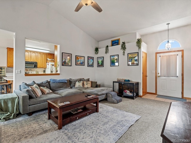 living room featuring baseboards, a ceiling fan, high vaulted ceiling, and light colored carpet