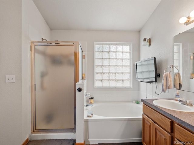 bathroom featuring a bath, vanity, and a shower stall