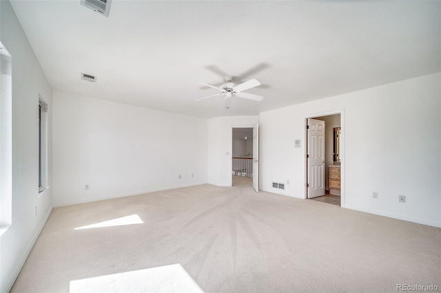 unfurnished bedroom with light colored carpet, baseboards, ensuite bathroom, and a ceiling fan