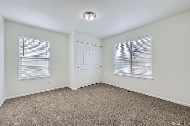 20000 E Mitchell Pl Unit 35, Denver, CO 80249 - unfurnished bedroom featuring carpet floors, baseboards, a closet, and a textured ceiling