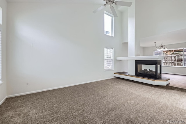 20000 E Mitchell Pl Unit 35, Denver, CO 80249 - unfurnished living room featuring a high ceiling, carpet flooring, baseboards, a multi sided fireplace, and ceiling fan