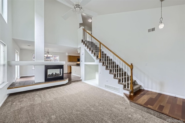 20000 E Mitchell Pl Unit 35, Denver, CO 80249 - unfurnished living room with a high ceiling, stairway, ceiling fan, baseboards, and carpet flooring