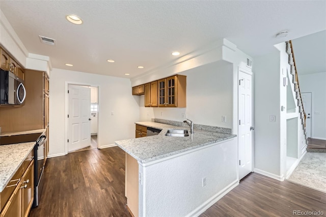 20000 E Mitchell Pl Unit 35, Denver, CO 80249 - kitchen featuring appliances with stainless steel finishes, brown cabinets, a sink, dark wood-type flooring, and light stone countertops