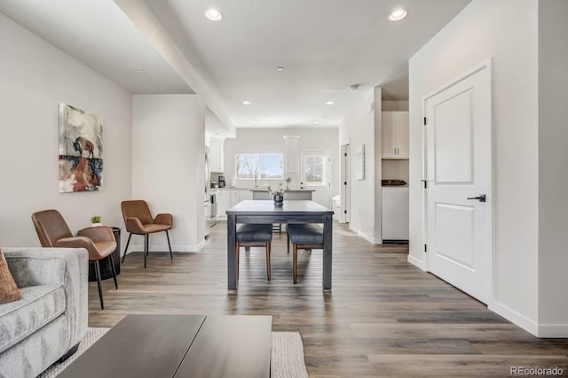 dining space with baseboards, wood finished floors, and recessed lighting