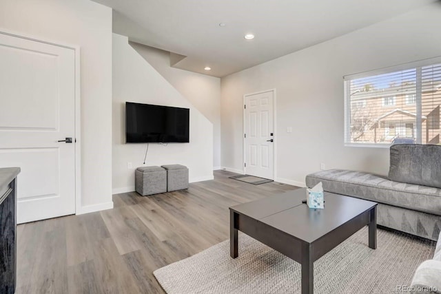 living room featuring baseboards, recessed lighting, and light wood-style floors