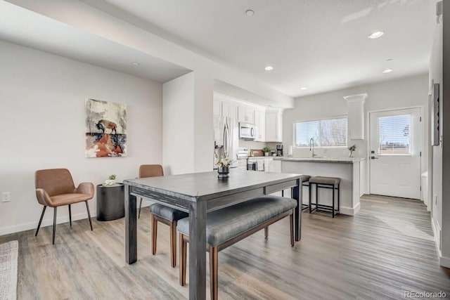 dining room with baseboards, recessed lighting, and light wood-style floors
