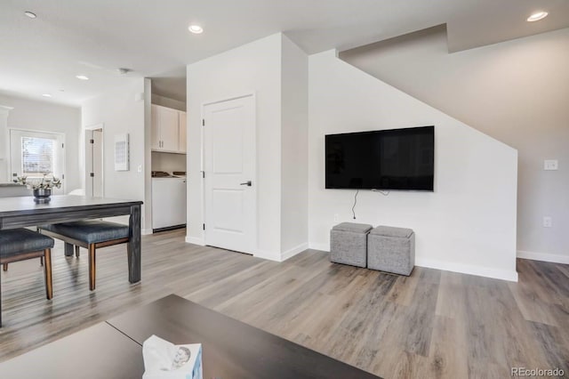 living room with recessed lighting, baseboards, washer / clothes dryer, and light wood-type flooring