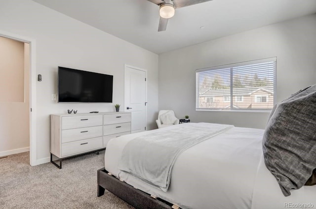 bedroom with light colored carpet, ceiling fan, and baseboards