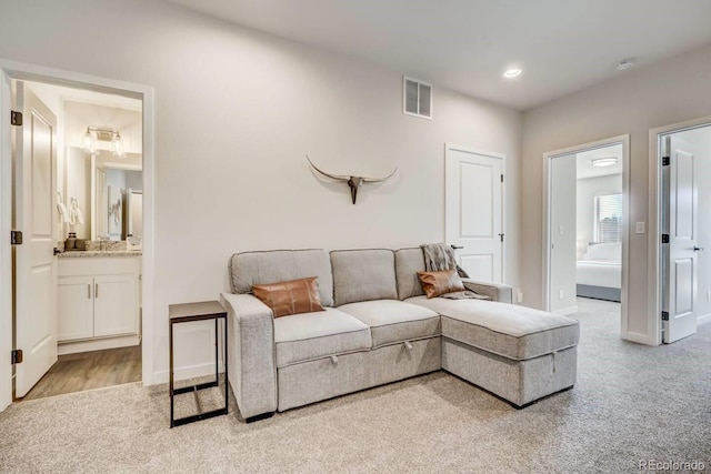 living room featuring light colored carpet, baseboards, visible vents, and recessed lighting