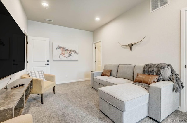 carpeted living room with baseboards, visible vents, and recessed lighting