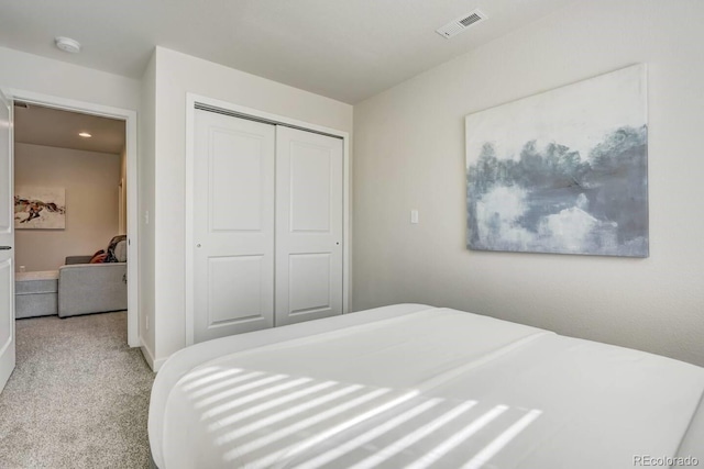 bedroom featuring visible vents, carpet floors, and a closet