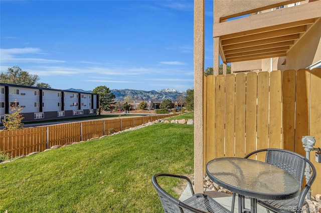 view of yard featuring fence and a mountain view