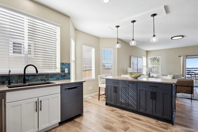 kitchen featuring dishwasher, light hardwood / wood-style floors, hanging light fixtures, white cabinets, and sink