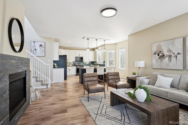 living room featuring a tile fireplace and light hardwood / wood-style floors