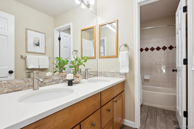 bathroom featuring tiled shower / bath combo and vanity